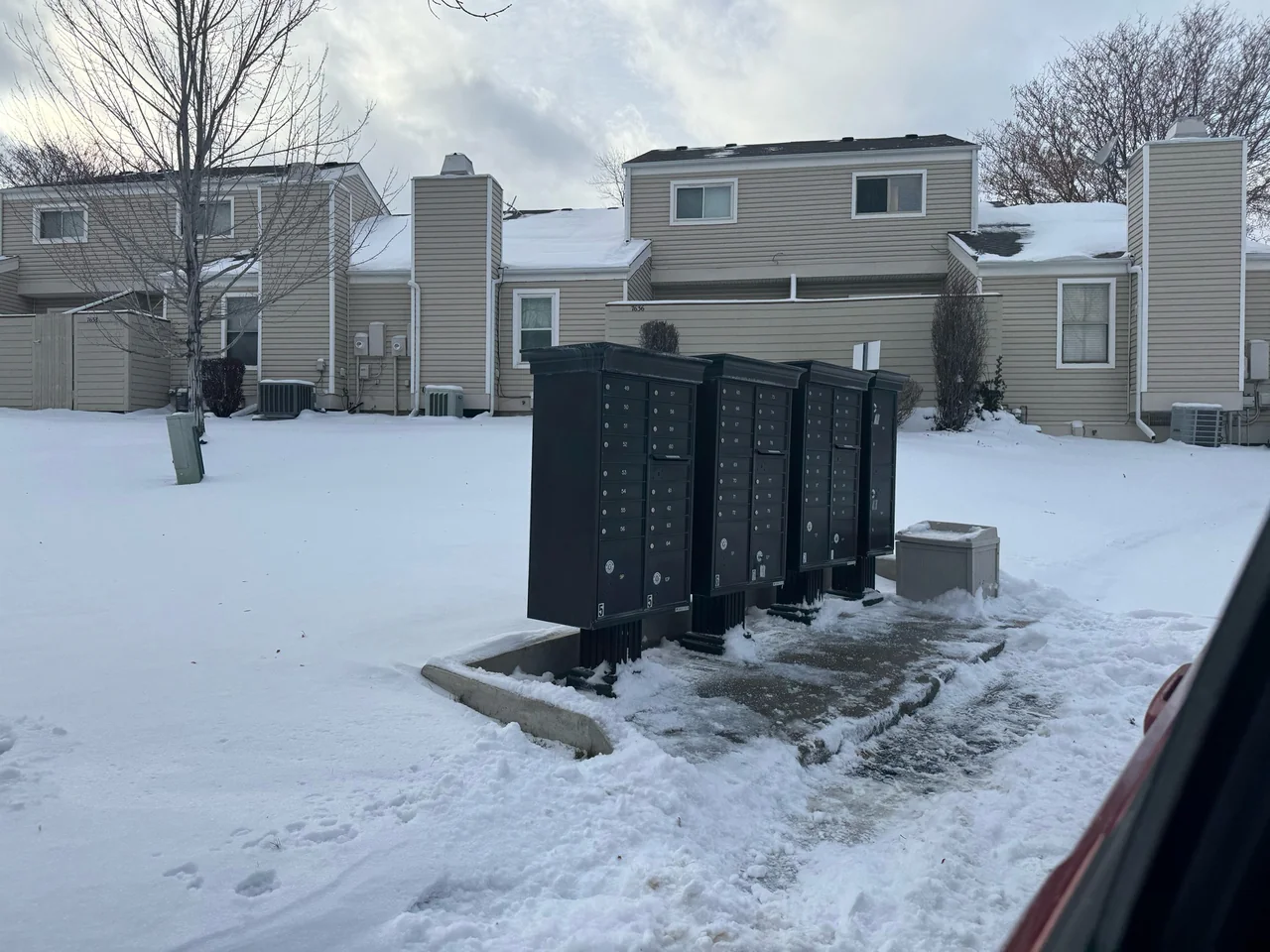Shared mailboxes with pavement exposed around the access area